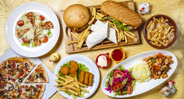 Top view fast food mix hamburger doner sandwich chicken nuggets rice vegetable salad chicken sticks caesar salad mushrooms pizza chicken ragout french fries mayo a Free Photo