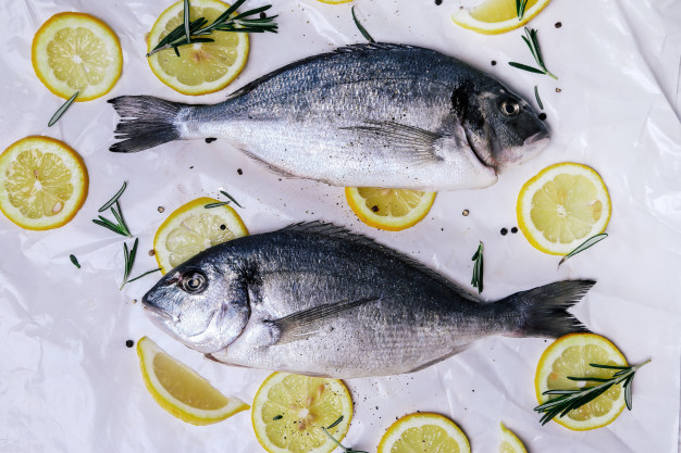 Fresh fish with lemon on white Free Photo