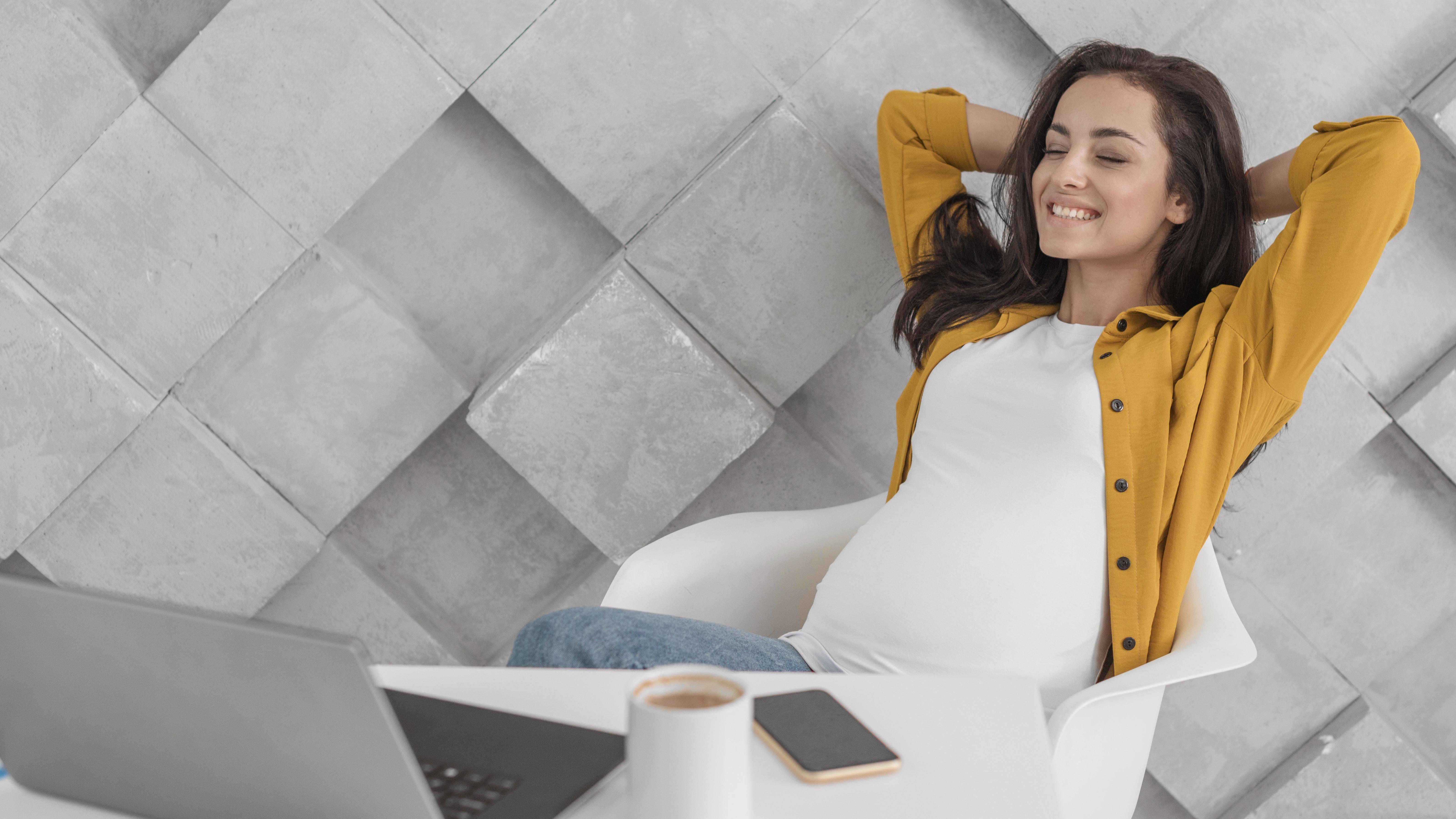 smiley-pregnant-woman-looking-her-laptop-home.jpg